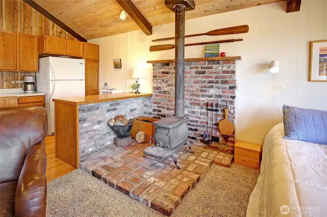 The wood stove kicks out the heat, and plenty of wood stacked below!