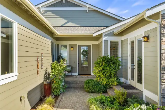 Welcoming covered entry with attractive, low maintenance landscaping...  Notice the private entry to the Home Office through French doors on the right.
