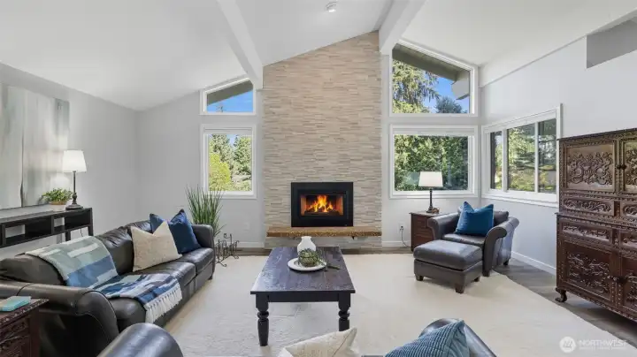 Vaulted ceilings and large windows provide a light filled great room, including newer gas fireplace wrapped in floor-to-ceiling Ledgestone.