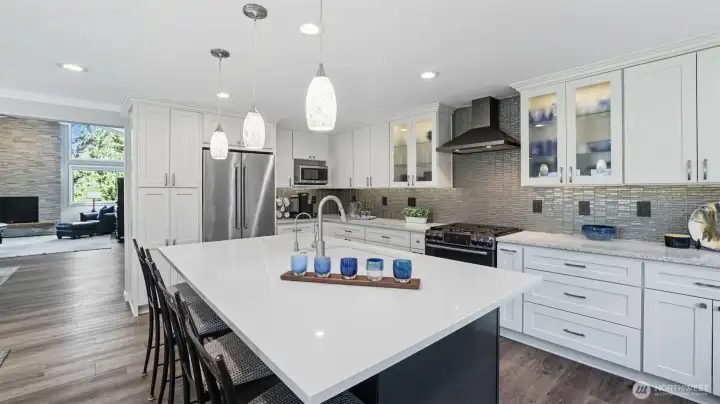 Recently remodeled kitchen with quartz countertops features a large center island with seating for four and extensive recessed lighting.