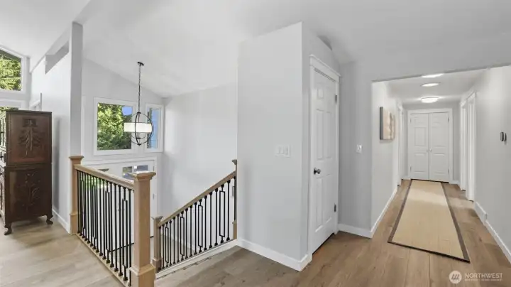Hallway leads to primary suite, 2 secondary bedrooms and full bath