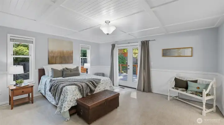 Spacious primary suite features French door access to the deck