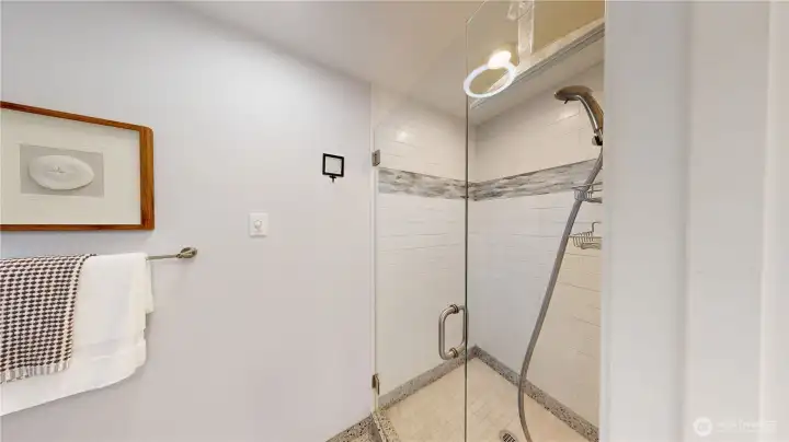 Designer tile and frameless glass door in this primary suite shower