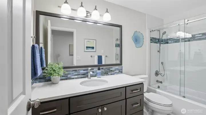 The two main floor bedrooms are serviced by a fully remodeled bath with contemporary design and colors