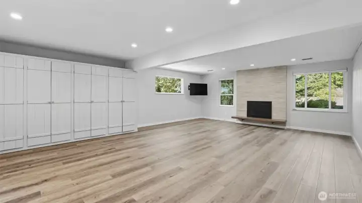 Lower level rec room with built-in cabinets and newer gas fireplace