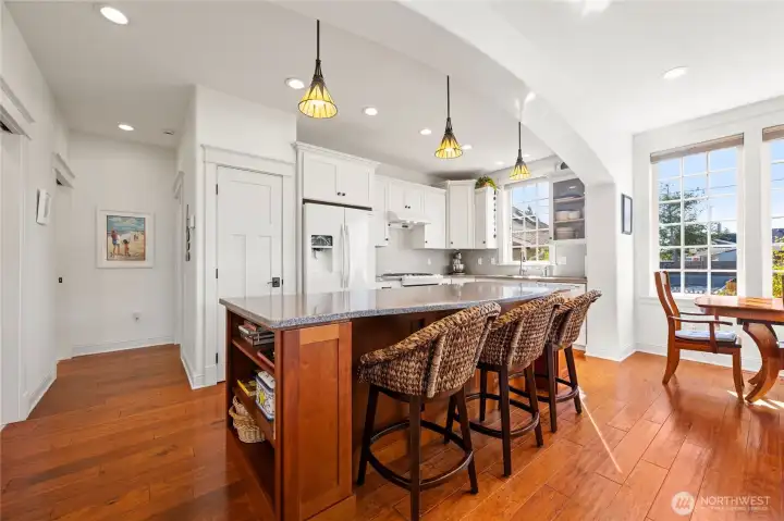 A view of the kitchen with the dining space in front of windows.