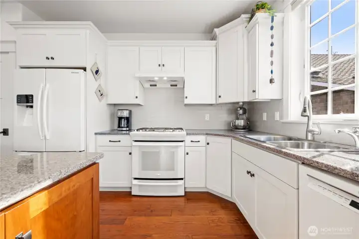 The spacious kitchen with painted cabinets and wood island