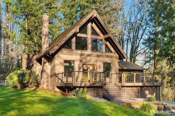This home features new landscaping and is framed by towering fir trees.