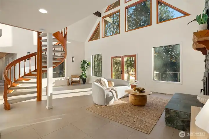 Dramatic great room showcases a soaring ceiling and wall of windows allowing the natural light to spill inside.