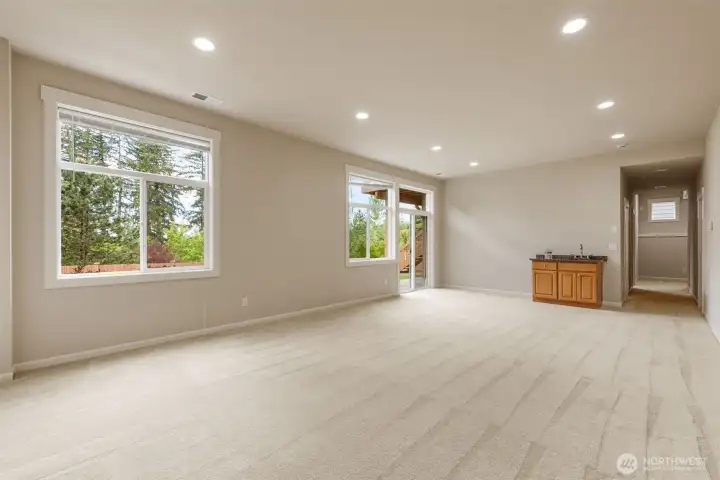 Walkout basement full of light with sink and sliding doors.