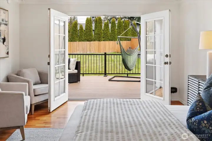 French doors off primary bedroom sitting area to new deck and backyard