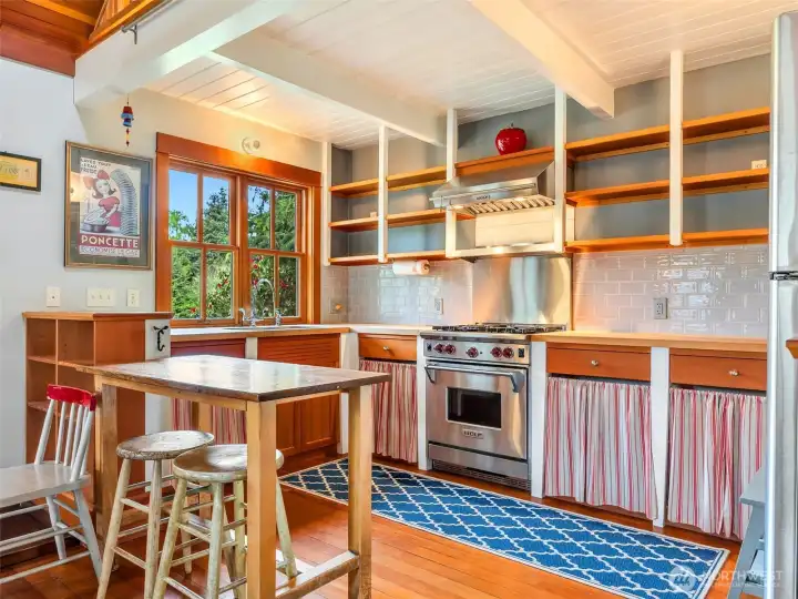 Open living space and kitchen with custom shelving and natural light