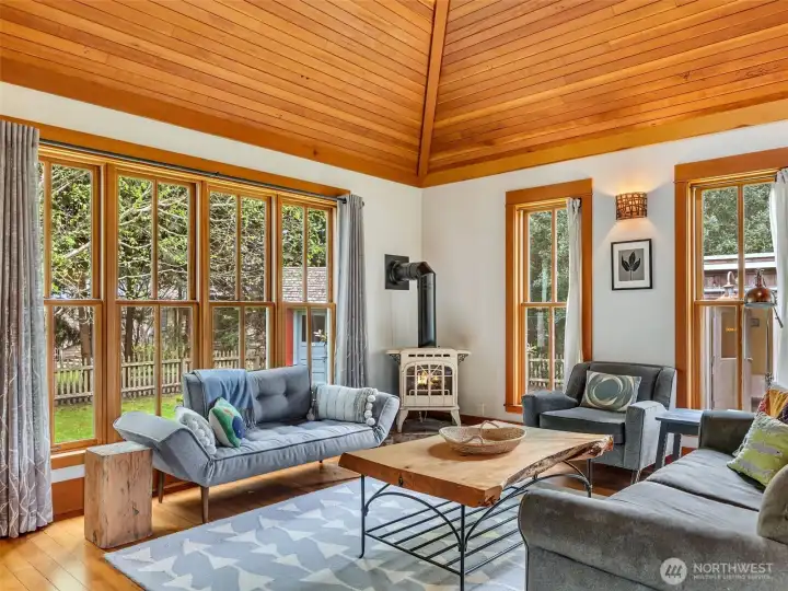 Living area with extensive built-ins and warm wood finishes. reclaimed wood ceiling from an old lumberjack bar in Oregon. Propane fireplace and inviting seating area.