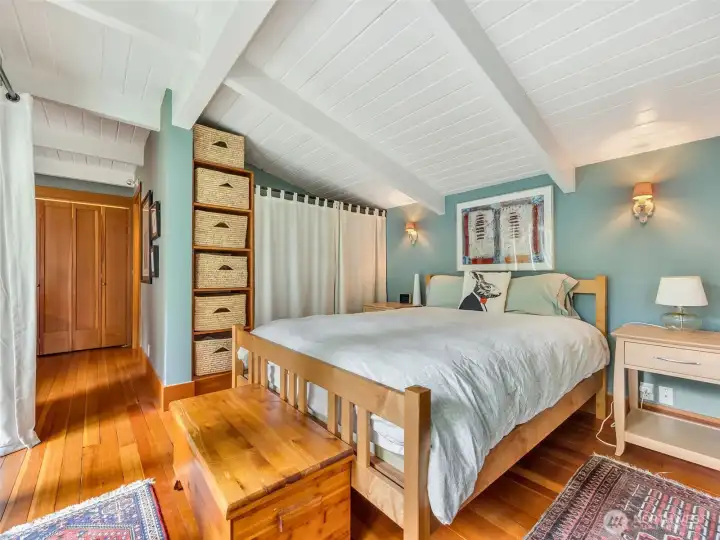 Main bedroom with vaulted ceiling and natural light