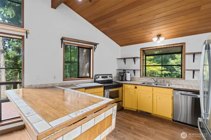 Rustic country kitchen with garden window and mountain view.