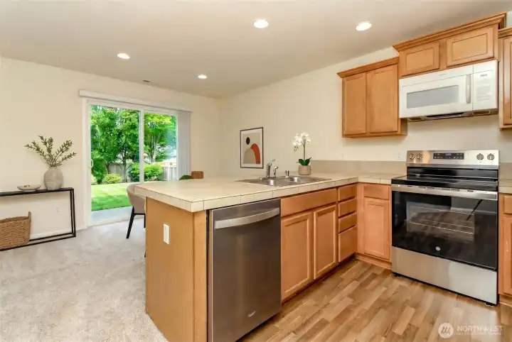 Kitchen  Functional kitchen featuring abundant cabinetry, generous counter space, stainless steel appliances, and a breakfast bar.