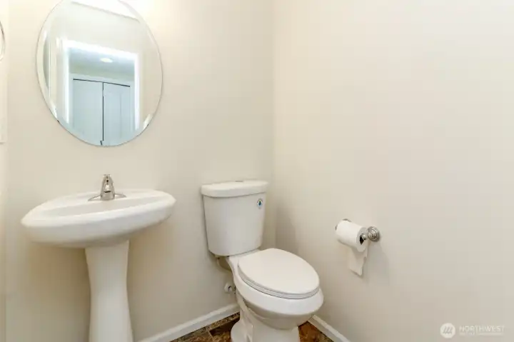 Main-Level Powder Room  Convenient main-floor powder room for guests, featuring a pedestal sink and modern fixtures.