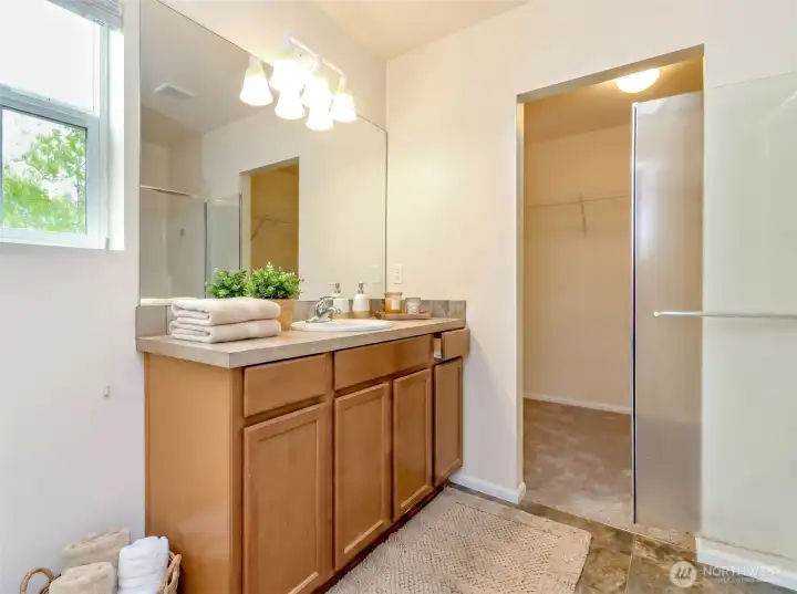 Primary Bathroom  Well-appointed primary bath with an oversized vanity, ample counter space, walk-in shower, and adjoining walk-in closet.