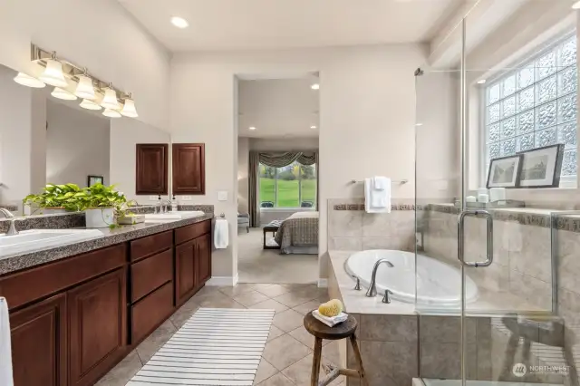 Gorgeous Primary 5 piece bath suite with private commode and linen closet. Tile surround soaking tub and shower adorned with acrylic glass window for privacy and light. This bath has a full walk in closet with custom shelving.