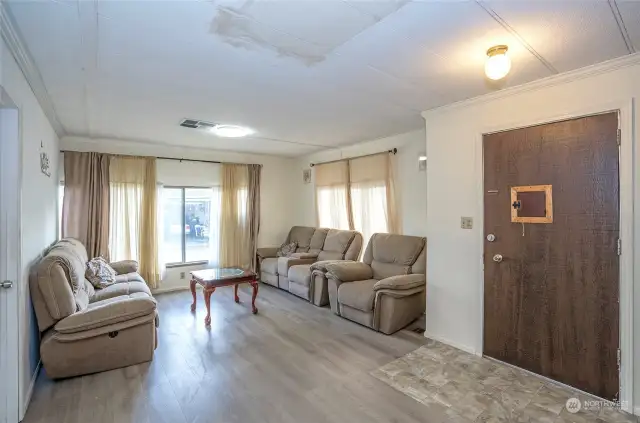 Bright and inviting living room featuring large windows and durable LVP flooring that extends throughout the entire home.