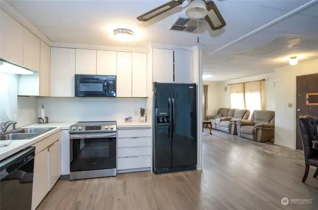 A view from the kitchen into the living room and entry area, showcasing the beautiful and low-maintenance LVP flooring.