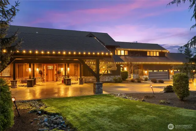 The Porte Cochere and circular driveway make entertaining and parking easy. The stamped concrete and timber supports create a beautiful and rustic design.
