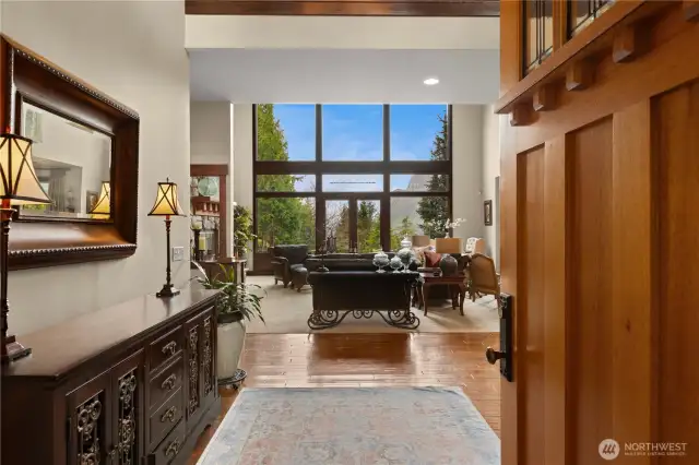 Open the front door to a double height foyer and living room with floor to ceiling windows framing a perfect view of Mt Si.