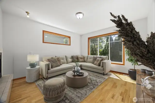 The living room is sunlit and spacious and looks to the forested area that is open space and cannot be built on.