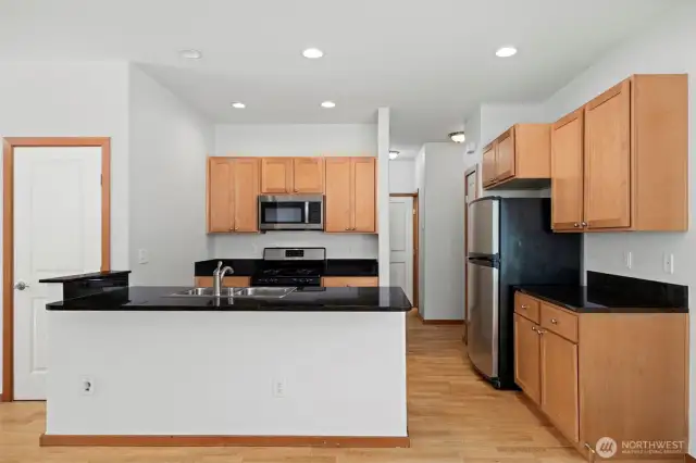 The kitchen has beautiful black granite counters and shaker-style cabinets.