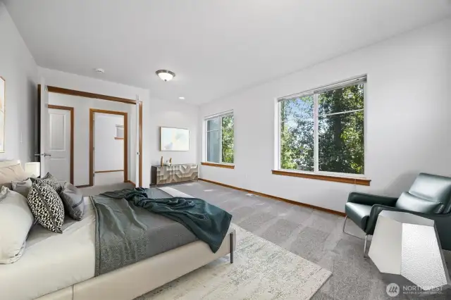 THe primary suite is very spacious and looks out toward the side yard and wooded area beyond.
