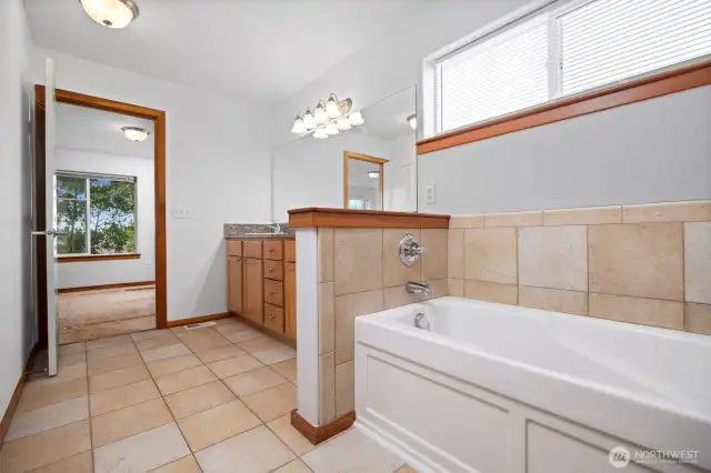 Looking back toward the primary bedroom from the tiled bath.