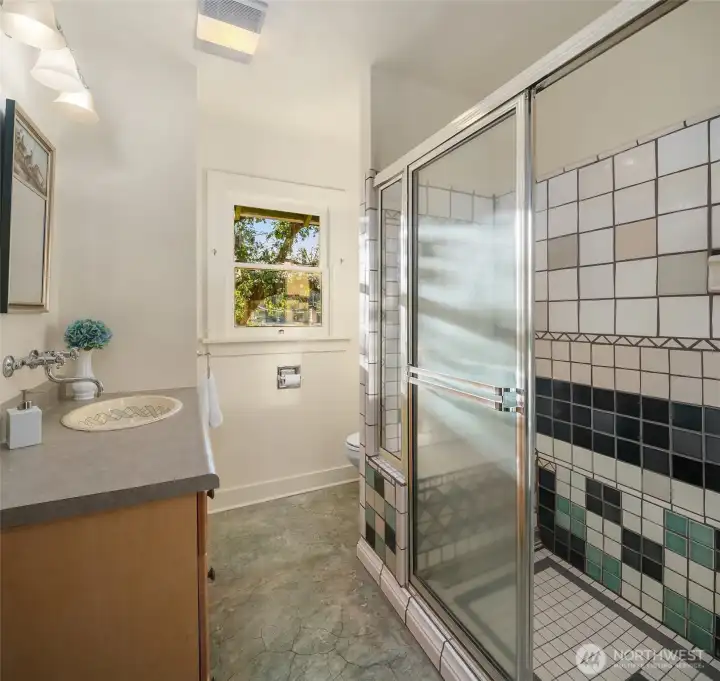 Main level 3/4 bath with custom tile shower and concrete floor.