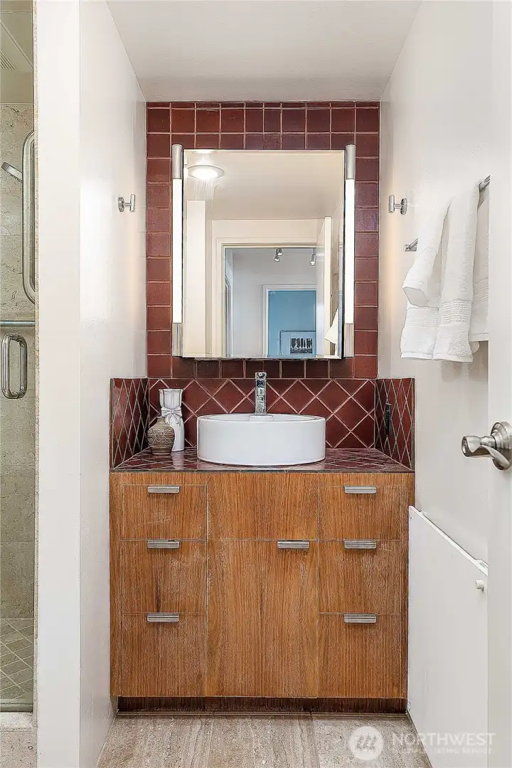The guest bath vanity and walnut cabinets, wall radiator heat
