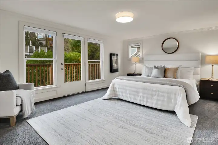 The primary suite is a true retreat, featuring a luxurious en-suite bathroom, walk-in closet, and a private balcony with glimpses of Lake Washington and the Cascade Mountains