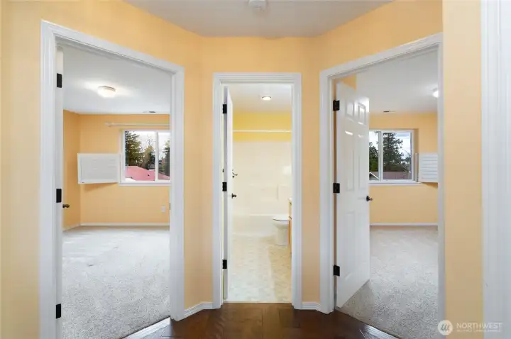 Upper floor landing with engineered hardwood floor, doorways to the two additional bedrooms and full bath.