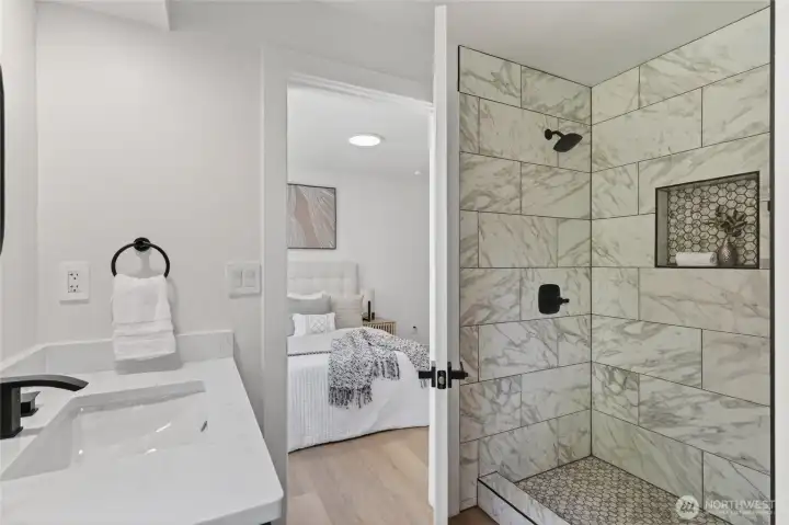 Enjoy a spa-like feel in the ensuite with a walk-in shower and custom tile detailing.