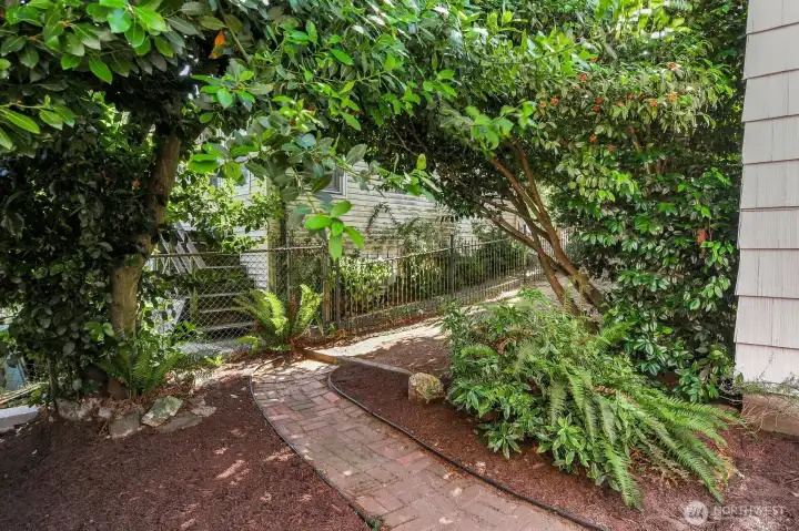 A brick pathway connects the deck and lower-level entrance to the main yard. A brick pathway connects the deck and lower-level entrance to the main yard.