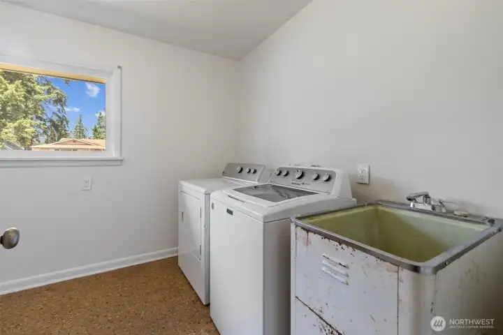 Washer, dryer and utility sink in utility room.