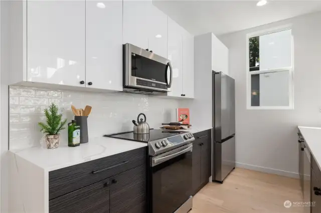 Beautifully designed kitchen with a blend of high-gloss cabinetry, stainless steel appliances, and a subway tile backsplash.