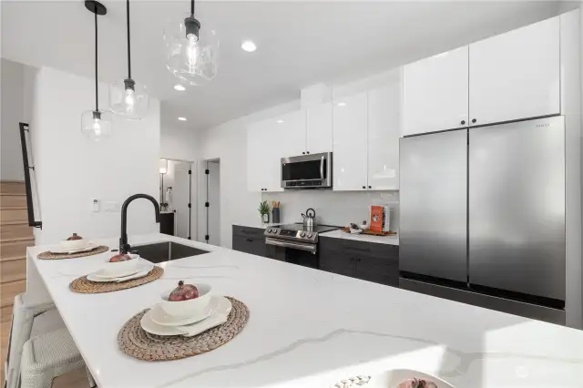 This kitchen is a chef's dream with premium appliances, quartz counterops, and pendant lighting adding a touch of elegance.