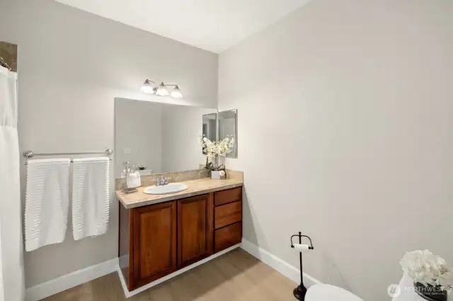 Guest bathroom is across the hall from the second bedroom. Also has all new flooring, tile counter tops and full tub surround.