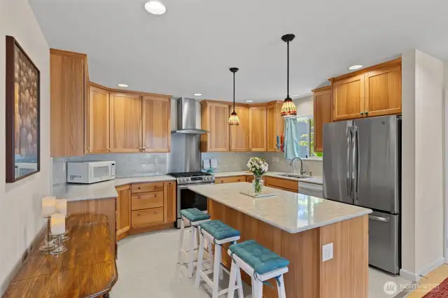 Stunning kitchen with quartz countertops, island seating, new lighting, soft close custom cabinets, stainless appliances!