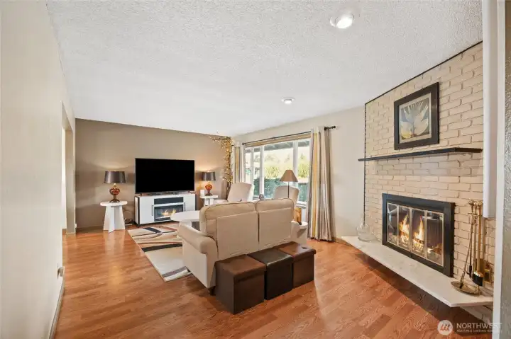 Living room with updated flooring and large windows