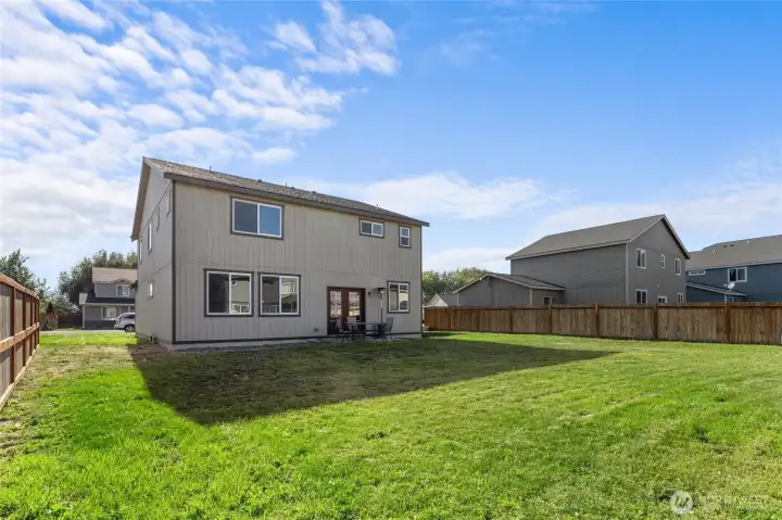 A large, flat, partially fenced yard with a  concrete patio right off the kitchen— ready for games, gardens, or gatherings. Bonus: irrigation system keeps things green (just  $45.50/month, April–October)