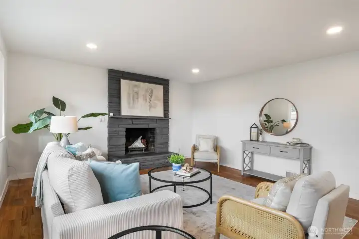 Large living room is anchored with a feature fireplace.