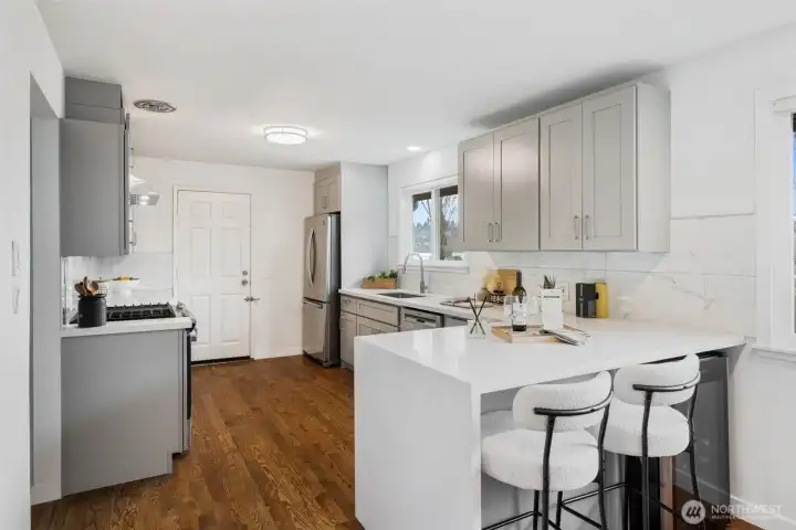 Updated kitchen with quartz counters and stainless appliances. Exterior door conveniently goes to the outside.