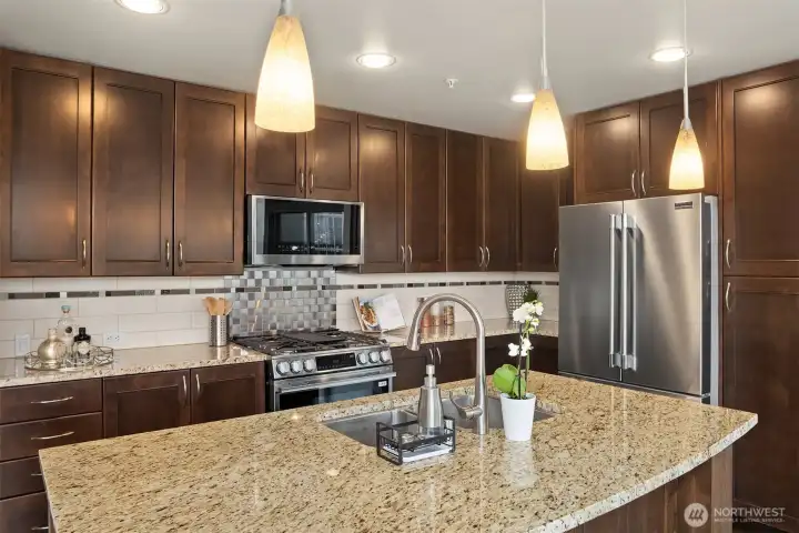 A curved slab-granite breakfast bar provides space for additional seating.