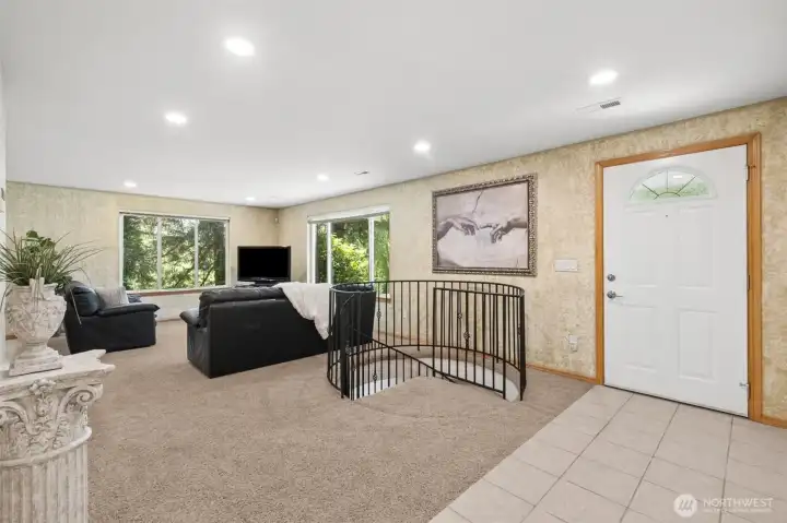 Main floor living room with spiral stair case to lower level