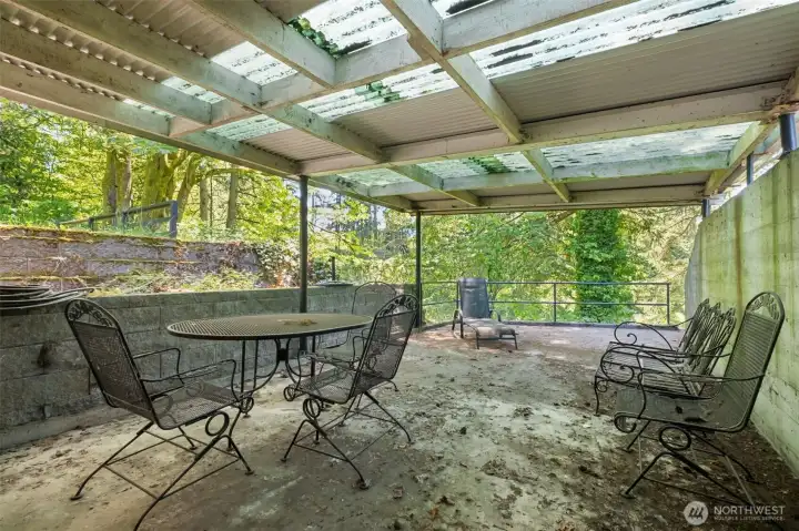 Outdoor covered patio off downstairs living room.  Creek and pasture are down the hill