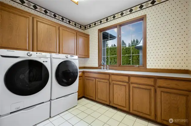 Large utility room with lots of cabinets, counter space and built-in ironing board.